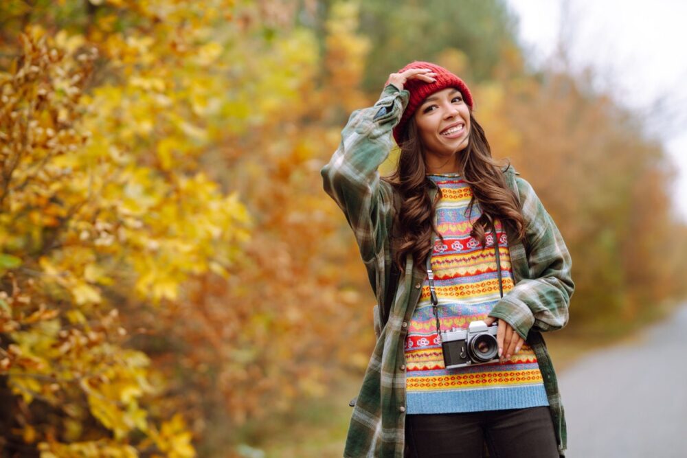 Graži jauna moteris fotografuojasi su retro fotoaparatu. Poilsis, atsipalaidavimas, kelionės, gyvenimo būdo koncepcija